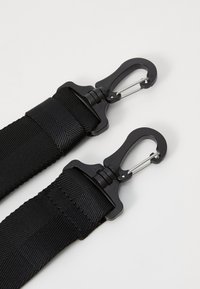 Black nylon straps with metal clips. Textured surface and sturdy design, featuring secure fastening hardware for durability.