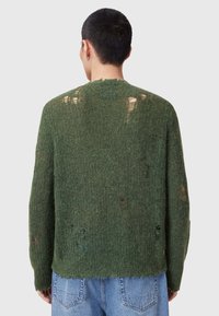 Zielony wełniany sweter o luźnym kroju, z wieloma przetarciami, teksturowanym materiałem i projektem z okrągłym dekoltem.