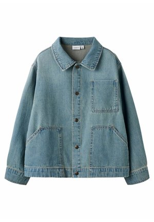 Lyseblå denimjakke med spiss krage, knappestolpe foran, en brystlomme og to skrå nedre lommer, lagt flatt på hvit bakgrunn.