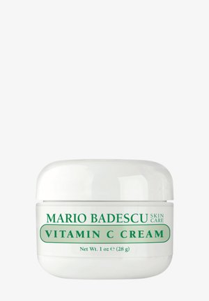 Barattolo bianco di crema alla vitamina C Mario Badescu con testo verde, 1 oz (28 g), contenitore di prodotto per la cura della pelle su sfondo semplice.