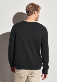 Pull en maille texturée gris foncé à manches longues et col rond, vu de dos. Design simple, adapté pour un style décontracté.