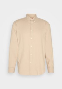 Chemise beige à manches longues avec petit motif à carreaux, col boutonné et boutons blancs sur le devant.