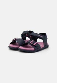 Kindersandalen mit einem marineblauen Obermaterial und pinken Akzenten, verstellbaren Riemen, einer Gummisohle und einer strukturierten Innensohle für zusätzlichen Komfort.