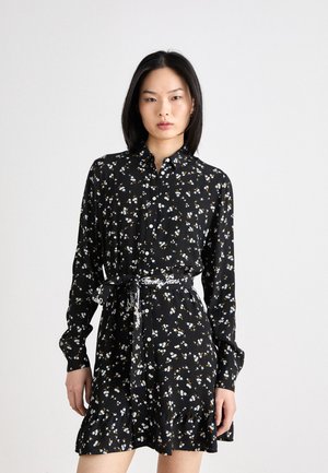 Abito floreale nero con bottini frontali, maniche lunghe e orlo arricciato. Decorato con piccoli fiori blu e gialli, include una cintura da annodare.