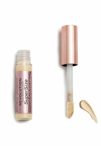 Concealer i en klar tube med en lyse beige nuance. Har en blød applikator-spids og et rosa gulddæksel. En beige swatch ved siden af.