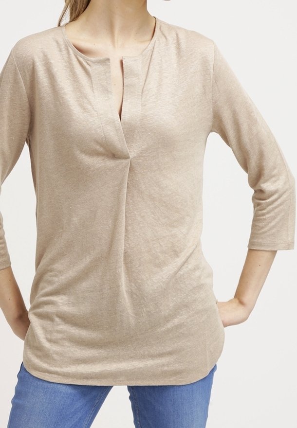 Top beige a maniche lunghe con scollatura rotonda, caratterizzato da una piccola apertura frontale e una vestibilità rilassata. Tessuto morbido e leggero con una texture sottile.
