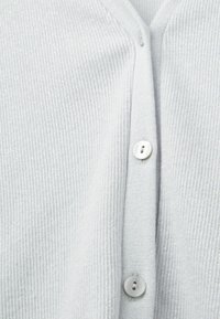 Jasnoszara, prążkowana kardigan z dekoltem w serek, z trzema białymi guzikami na przodzie, teksturowany materiał z subtelnym połyskiem.