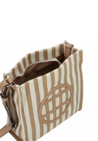 Gestreepte tan- en crèmekleurige stoffen tas met leren accenten, een ritsvak aan de binnenkant en een opvallend rond logo aan de voorkant.