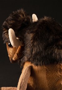 Brown plush bison toy with a soft, textured body, black fur on the head and back, beige accents on the ears, and large, round eyes.
