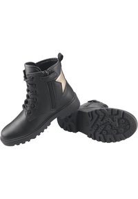 Botas de tobillo de cuero negro con cordones en la parte delantera y cremalleras laterales. Suela de goma texturizada con un patrón de tracción resistente. Acabado dorado en el lateral.
