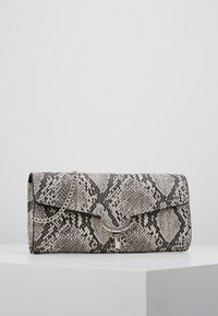 Obdélníková psaníčko s černobílým hadím potiskem, s kovovým řetízkem a kovovým zapínáním.