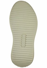 Biała gumowa podeszwa butów z poziomymi rowkami i wypukłymi żłobieniami, z wytłoczonym napisem "STEVE MADDEN" na środku.