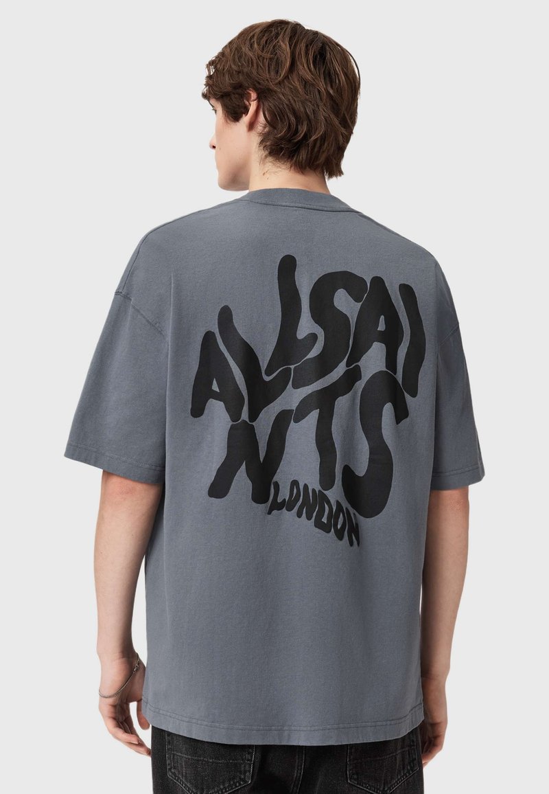 T-shirt de algodão cinza com um corte solto, apresentando um grande texto abstrato preto nas costas que diz "ALLSAINTS LONDON." Mangas curtas, decote redondo.