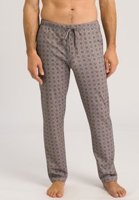 Comfortabele gestreepte pyjamabroek van zacht materiaal. Heeft een lichtbruine basis met marineblauwe bloemenpatronen, een trekkoord in de taille en recht gesneden pijpen.