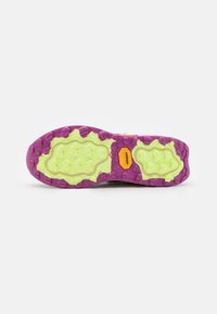 Purple and lime green outsole with textured pattern and prominent treads. Features a label in orange near the center for traction.