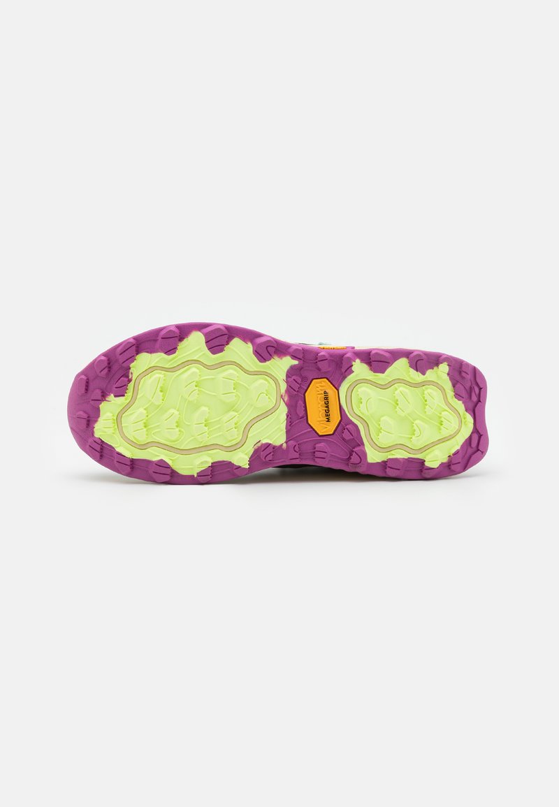 Suela en púrpura y verde lima con un patrón texturizado y treads prominentes. Presenta una etiqueta en naranja cerca del centro para mayor tracción.
