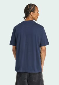 Námornícky modré bavlnené tričko s krátkymi rukávmi, okrúhlym výstrihom a voľným strihom. Obsahuje minimálne švy a hladkú textúru.