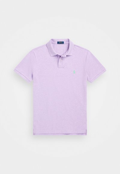 Gaiši purpursarkans polo krekls, izgatavots no kokvilnas, ar apkakli, īsām piedurknēm un mazu zaļu logo kreisajā krūtīs. Klasisks dizains.