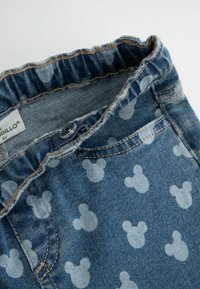 Niebieskie dżinsowe spodnie dziecięce z elastycznym pasem i wzorami w jasnoniebieskie głowy Myszki Miki.