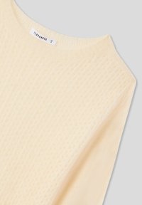 Maglione lavorato a maglia color crema con motivo testurizzato, scollo rotondo e etichetta che indica la taglia S. Materiale liscio e leggero, finitura morbida.