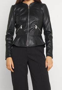 Černá kožená peplum bunda s texturovaným povrchem, kulatým výstřihem, předním zipem a dvěma zipovými bočními kapsami.
