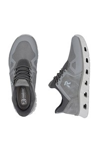 Chaussures de sport grises avec une tige en maille, une semelle en caoutchouc et un système de laçage. Texture à motifs avec des accents contrastants et un logo sur le côté.