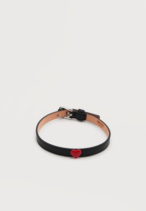 Μαύρο κολιέ από δέρμα με μικρό κόκκινο καρδιά κρεμαστό στο κέντρο και ρυθμιζόμενο ασημένιο κούμπωμα.