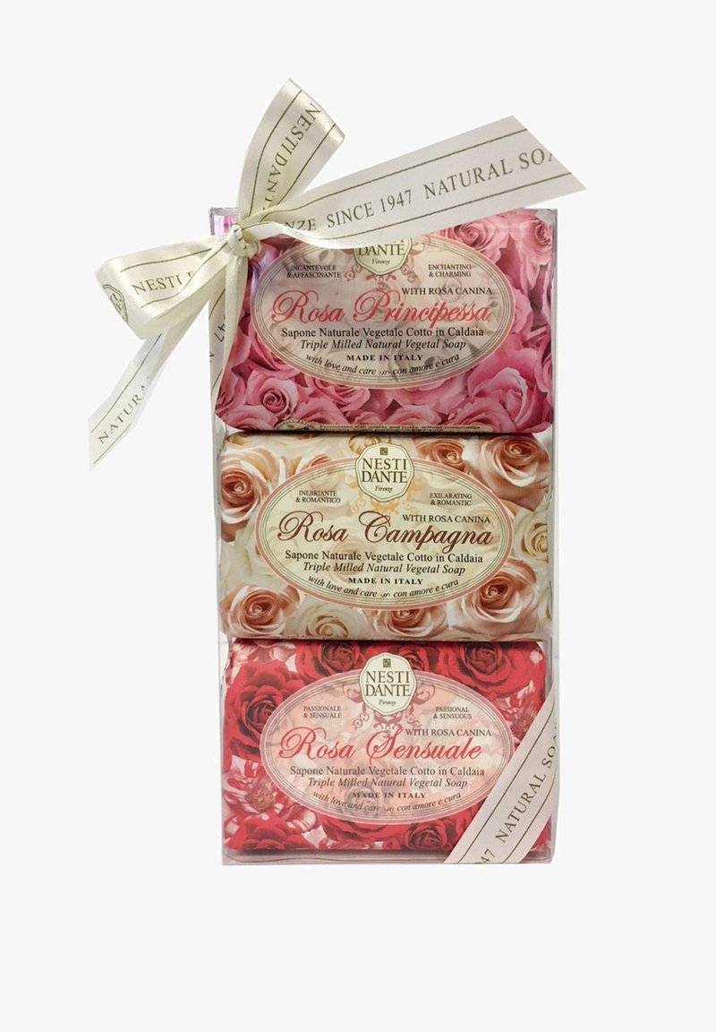 Drei gestapelte Nesti Dante dreifach gemahlene Naturseifenstücke mit rosenthemenbezogener Verpackung, zusammengebunden mit einem cremefarbenen Markenband.