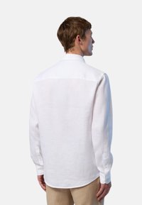 Camicia bianca in lino a maniche lunghe con colletto button-down, caratterizzata da un semplice design sul retro e bottoni ai polsini.