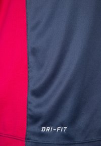 Lühikeste varrukatega spordipaita, mis on tumeda sinise ja roosa värvi blokeeringu disainiga, valmistatud hingavast kangast, mille alumises osas on "DRI-FIT" bränding.