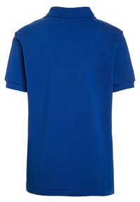Niebieska koszulka polo z krótkim rękawem pokazana z tyłu, z prążkowanym kołnierzykiem i mankietami, o gładkim wzorze i teksturowanym materiale.