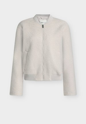 Heledhall hall, tekstuuriga bomber-jakk, millel on lukuga ees, ribikätid ja ümmargune kaelus. Omab küljetaskuid ja pehmet, mugavat välimust.