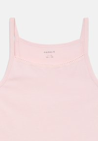 Light pink tank top with thin straps, soft cotton material, and a smooth texture. Features a lace accent along the neckline. Brand label inside.