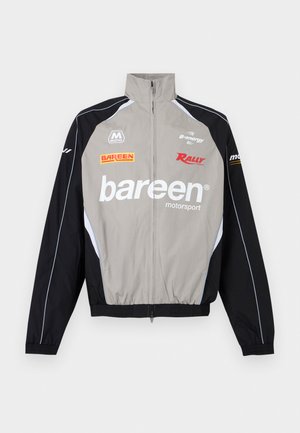 Grijs-zwart motorsportjack met hoge kraag, ritssluiting aan de voorkant en logo's waaronder "bareen", "Rally" en "B-energy" op de borst en mouwen.