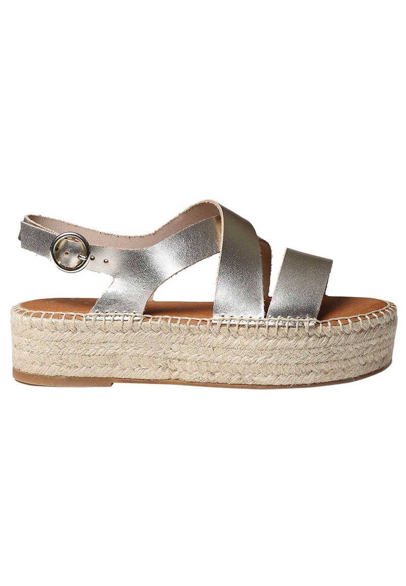 Metalen zilveren espadrille sandalen met kruisbanden, verstelbare enkelgesp en een geweven juten platformzool. Glad leren textuur.