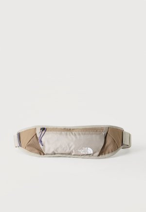 Banane beige clair et marron avec fermeture éclair et logo The North Face sur la poche avant, conçue pour une utilisation en extérieur ou décontractée.