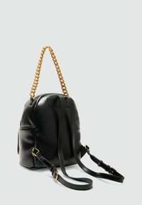 Zaino in pelle nera con forma arrotondata, dotato di manico in catena dorata, spallacci in pelle regolabili e superficie texture.