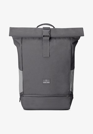 Szürke, roll-top hátizsák tartós nylonból, csattal záródik, oldalsó zsebbel rendelkezik, textúrált felülettel és logóval ellátott folt található az elején.