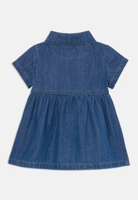 Denim haljina s okovratnikom, kratkim rukavima, nabranim strukom i lepršavom suknjom. Ima čistu plavu boju i vidljive šavove.