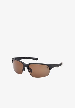 Gafas de sol deportivas negras semi sin montura con lentes tintadas marrones y varillas curvadas, colocadas en un ligero ángulo sobre fondo blanco.