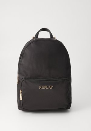 Mochila de tela negra con bolsillo frontal con cremallera, cremalleras doradas y logo "REPLAY" en letras doradas en el bolsillo.
