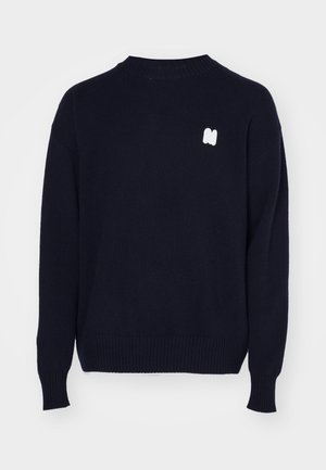 Dunkelblaues Strickpullover mit geripptem Rundhalsausschnitt, überschnittenen Schultern und einem weißen Logo-Akzent auf der Brust. Weiche Textur mit langen Ärmeln.