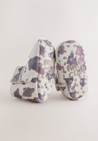 Bottines en daim doux de couleur blanc cassé avec un motif abstrait multicolore, dotées d'une bride à scratch et d'une semelle texturée avec un logo.