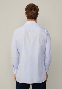 Camicia a scacchi azzurro chiaro con maniche lunghe, polsini abbottonati e colletto classico. Tessuto liscio con una leggera lucentezza, vista posteriore.