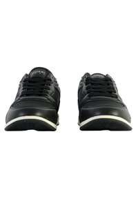Scarpe da ginnastica nere con una parte superiore in sintetico liscia, design con lacci e suola in gomma bianca. Presentano una superficie texturizzata e un marchio sulla linguetta.