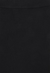 Černá ribkovaná látka s vertikálními pruhy a texturovaným povrchem. Jednoduchý design, bez jakýchkoli vzorů nebo akcentů.