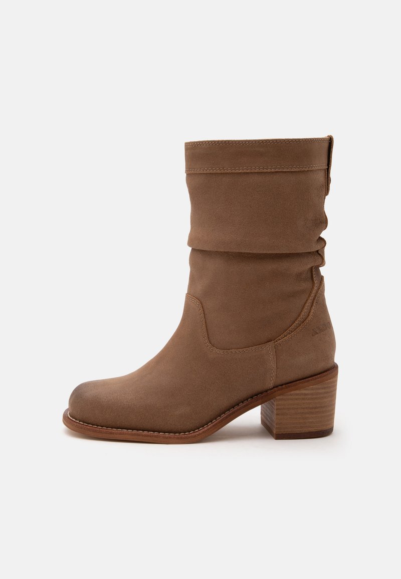 Botte mi-mollet en daim marron avec un bout arrondi, un dessus souple et un talon bloc en bois empilé.