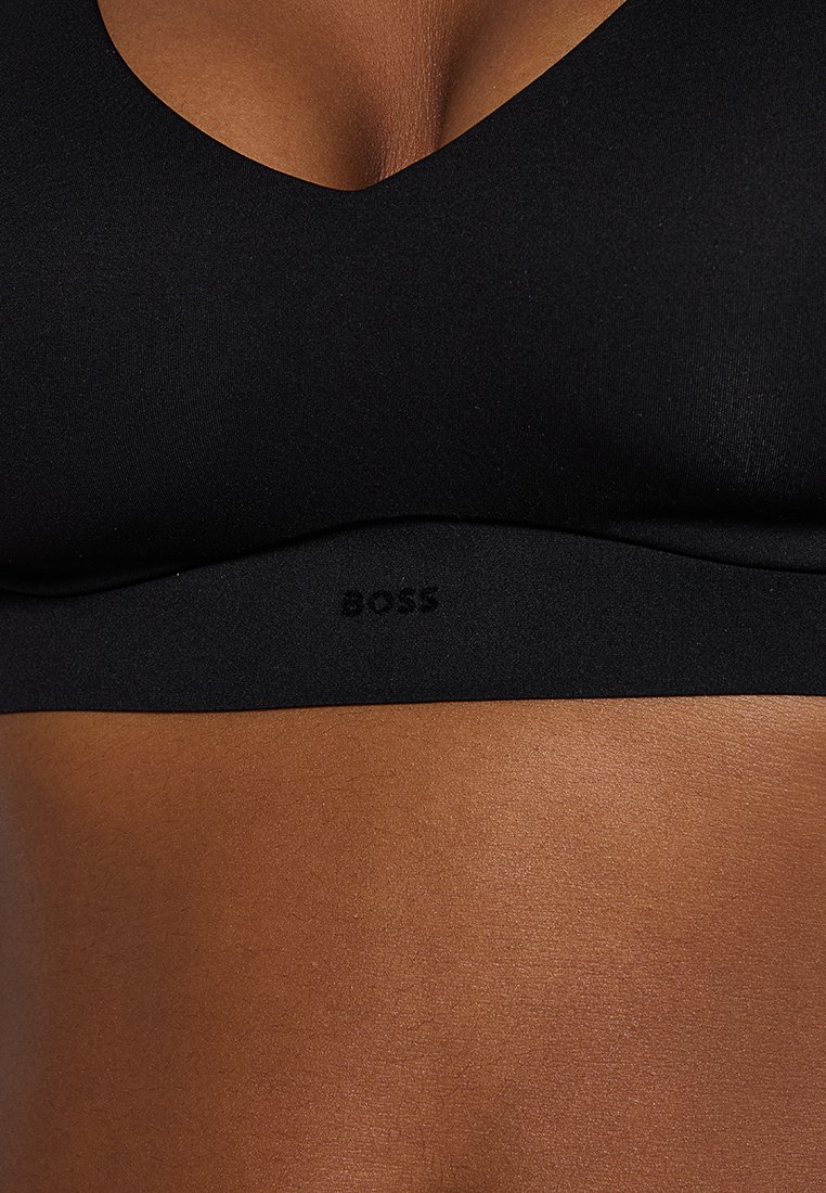 Schwarzer Sport-BH mit V-Ausschnitt-Design, hergestellt aus glattem Stoff. Verfügt über ein dezentes "BOSS"-Logo am Band unter der Brust.