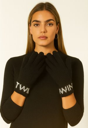 Guanti neri in maglia con polsini a costine, decorati con il testo bianco "TWIN". I guanti hanno una trama liscia e una vestibilità aderente per garantire calore.