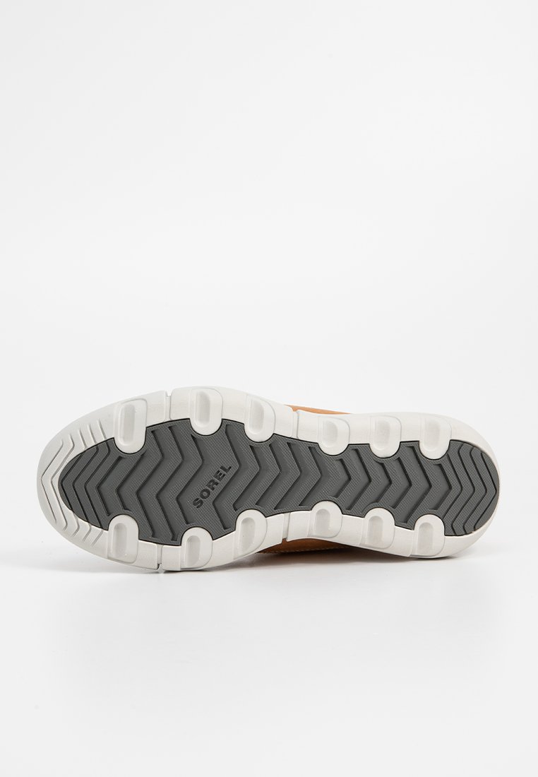 Baskets marron avec une tige texturée, dotées d'une semelle intermédiaire blanche et d'une semelle extérieure en caoutchouc gris avec des motifs de crampons en zigzag.